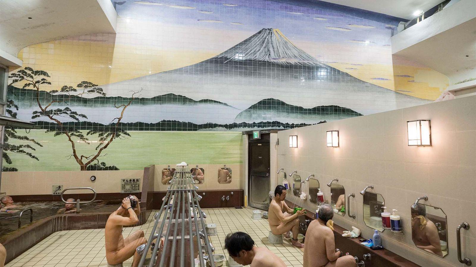 Un grupo de hombres desnudos en un baño tradicional japonés.