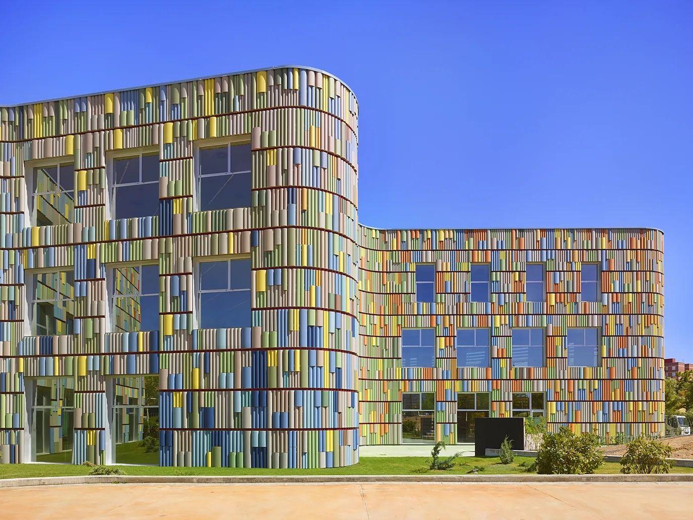 Un cubo compuesto de diferentes paneles de cristal, algunos transparentes, algunos de colores.
