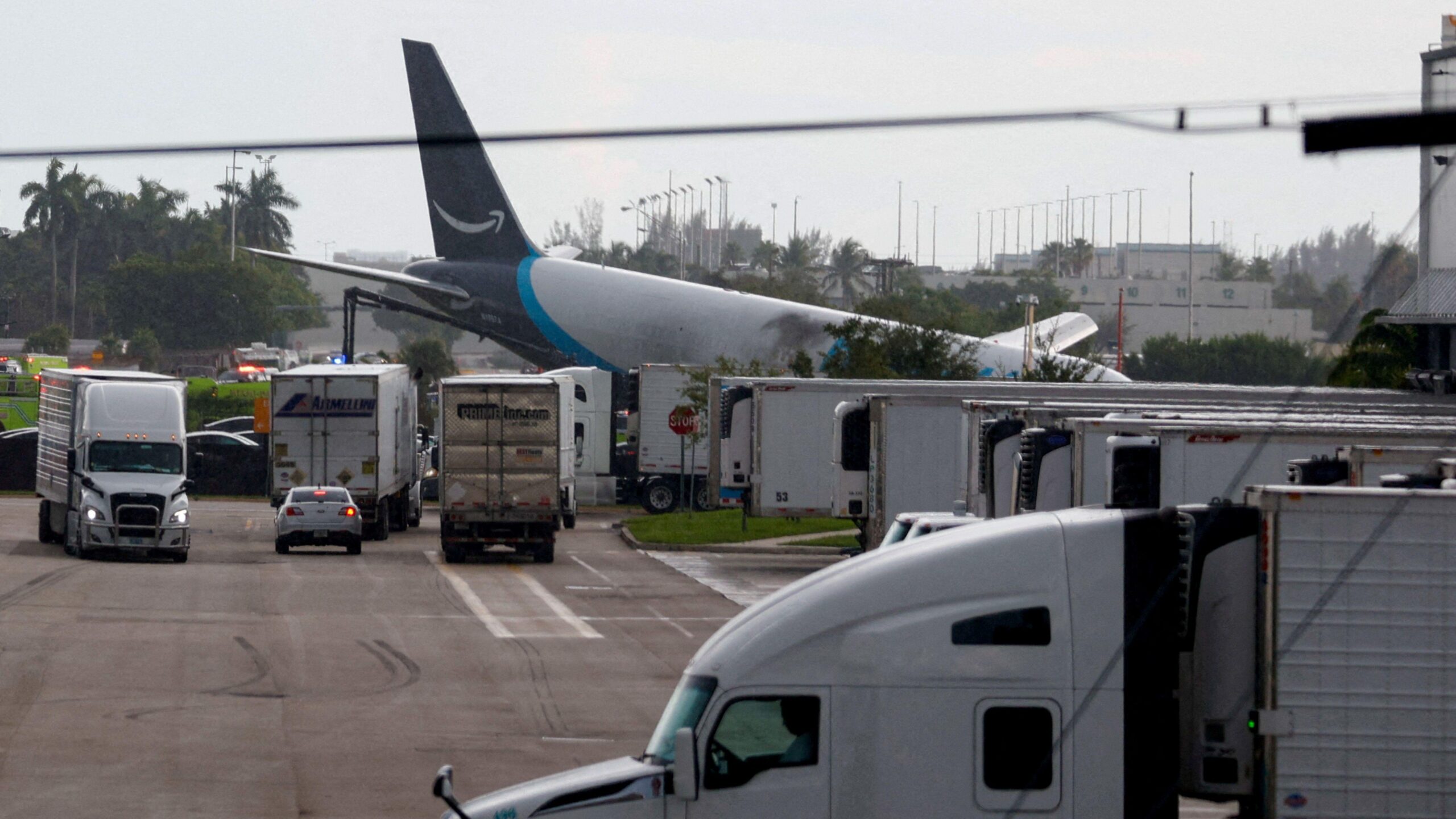 Un avión ladeado cerca de un estacionamiento de vehículos. Se ve que sufrió un incendio.
