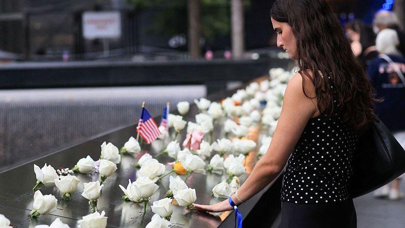 Mujer con flores en el memorial del 11-S