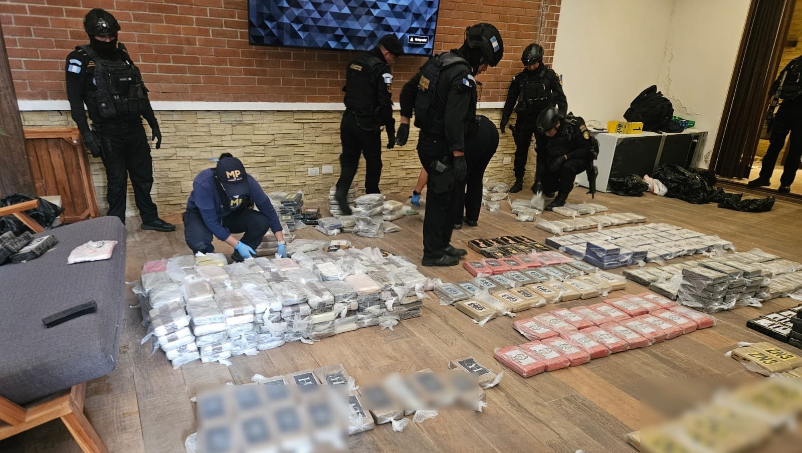 Paquetes con supuesta cocaína fueron localizados por agentes de la SGAIA durante las diligencias antinarcóticas efectuadas en un inmueble de Santa Catarina Pinula. (Foto Prensa Libre: PNC)