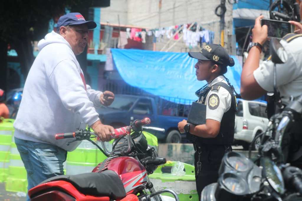 Oswaldo Villalta es cuestionado por un agente de la PNC durante bloqueo en La Bethania