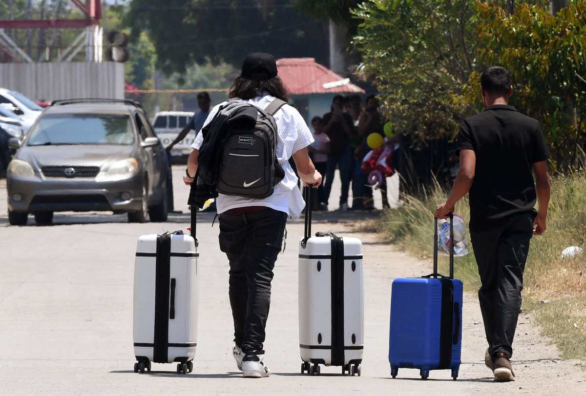 Men leave the Ramon Villeda Morales airport, where they arrived self-deported from the United States, in San Pedro Sula, 180 km north of Tegucigalpa, on May 19, 2025. A total of 38 Hondurans, including 19 children, who took advantage of President Donald Trump's anti-immigrant program, known as self-deportees, received the equivalent of USD 130 in cash and food stamps upon their arrival, after being welcomed by the government of President Xiomara Castro. (Photo by Orlando SIERRA / AFP)
