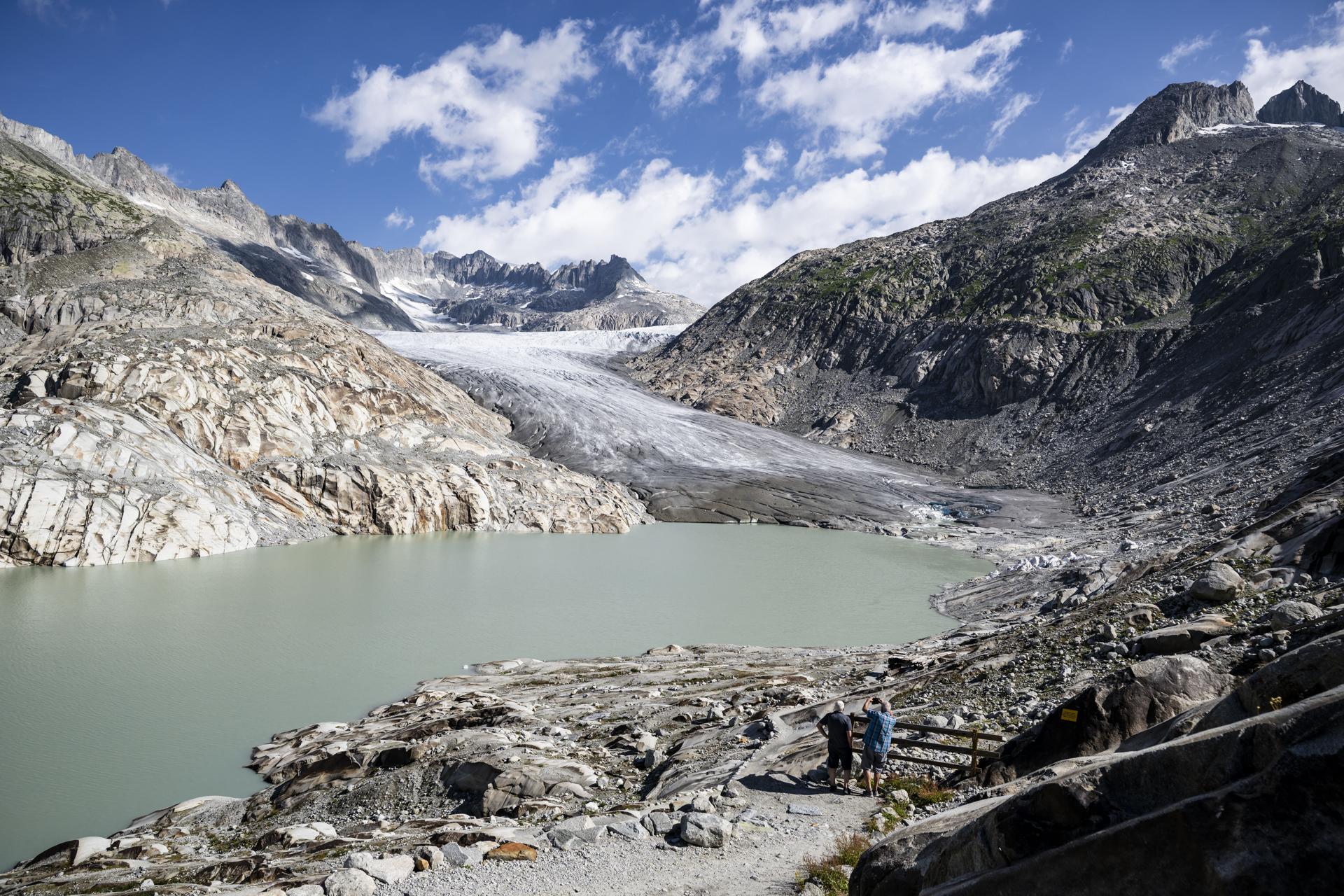 Turistas observan cómo se derrite el hielo frente a la lengua del glaciar del Ródano (Rhonegletscher) en los Alpes del cantón de Valais, Suiza, en una imagen de julio pasado. EFE/EPA/JEAN-CHRISTOPHE BOTT