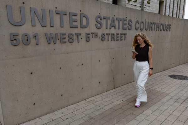 Una mujer fue captada, este 30 de septiembre, al caminar frente a un juzgado federal -durante la audiencia de Wilber Carcés, migrante venezolano a quien un agente de ICE disparó hace más de una semana- en Austin (TX, EE.UU.). EFE/Carlos Ramírez