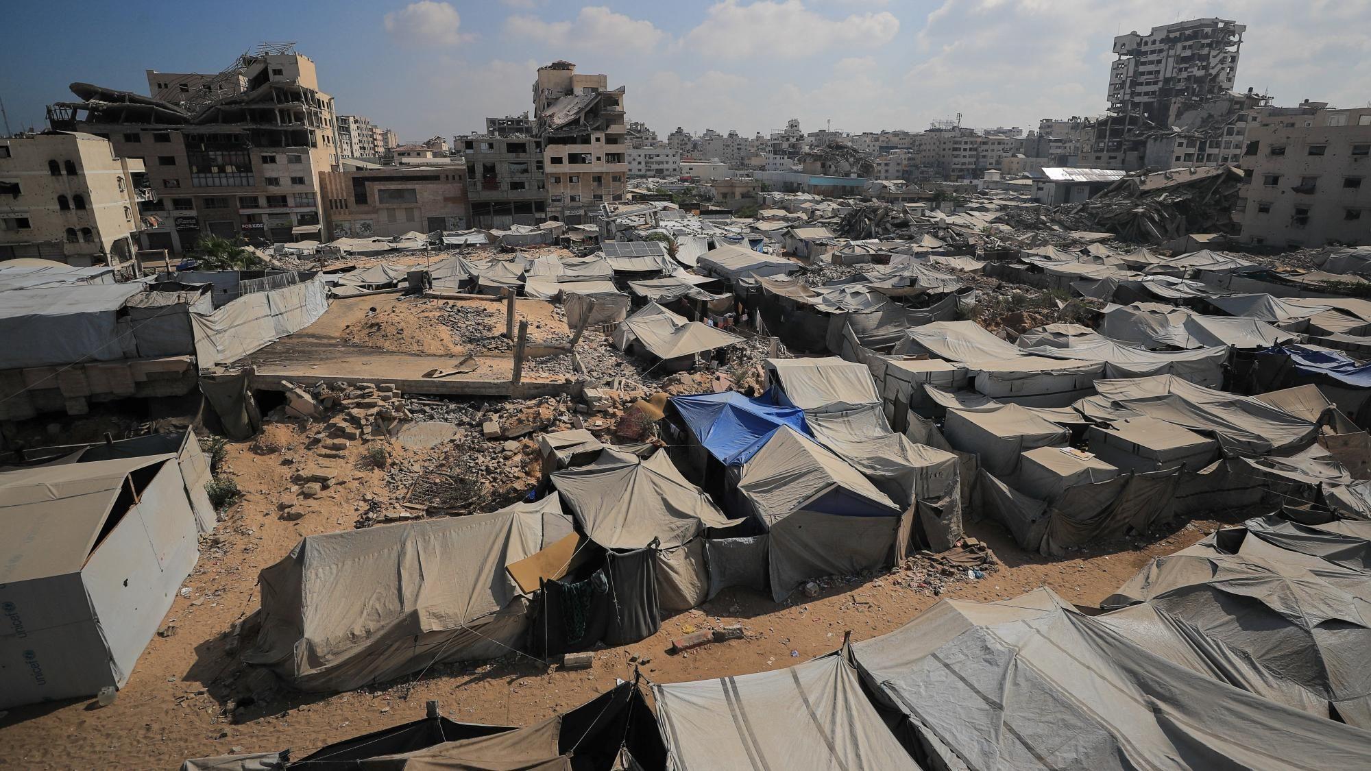 A file photo showing a Palestinian woman inspecting her damaged home after an Israeli strike on a nearby mosque, in Gaza City (29 July 2026)