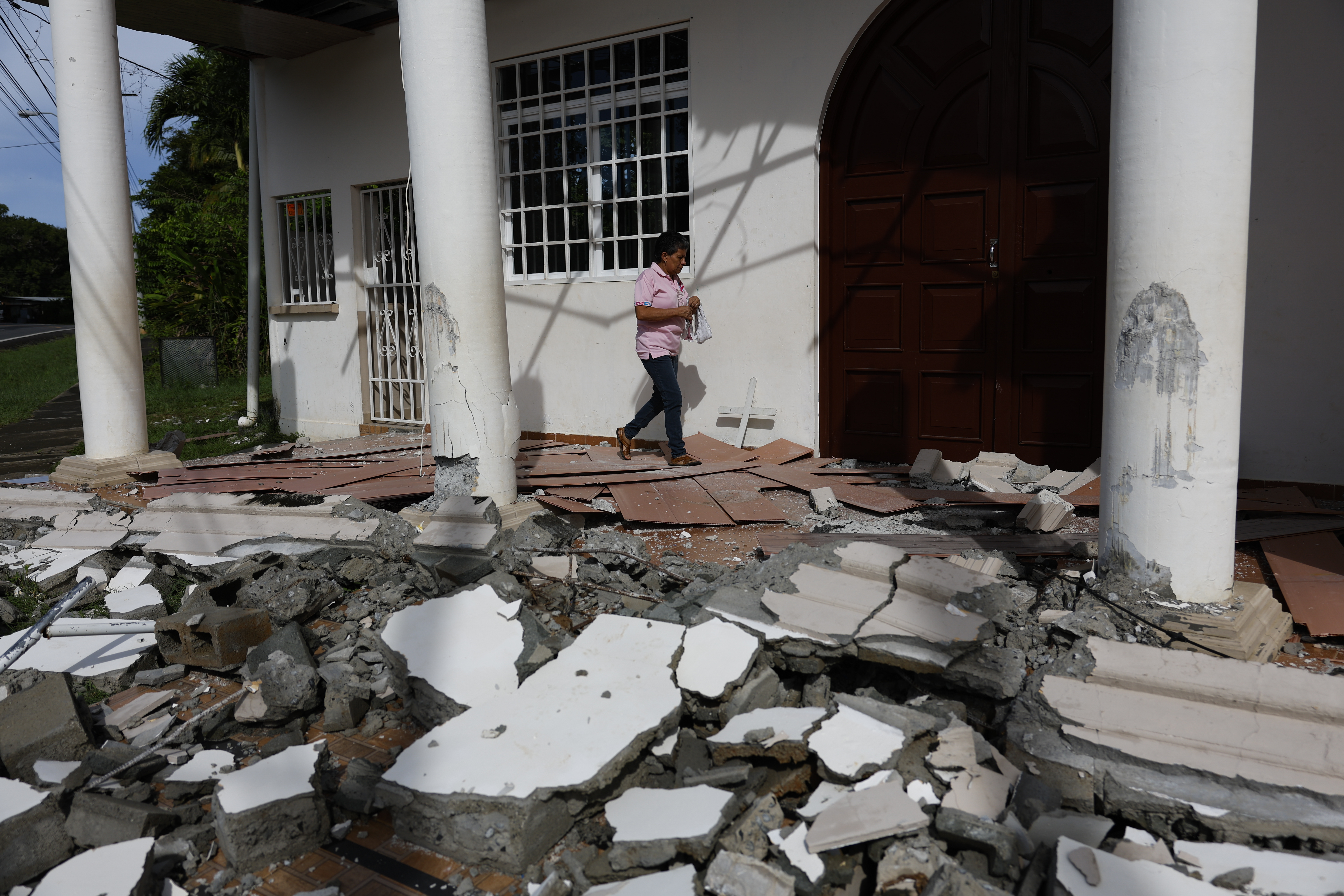 AME5709. LA COLORADA (PANAMÁ), 13/10/2026.- Fulvia Pérez camina este martes entre los escombros ocasionados por el terremoto de magnitud 7,7 del pasado viernes en la Capilla de San Sebastián en La Colorada (Panamá). El potente terremoto que azotó a Panamá, causó daños en las residencias de 2.164 familias, entre ellas 506 que registraron la pérdida total de sus hogares, según el último reporte oficial. EFE/ Bienvenido Velasco