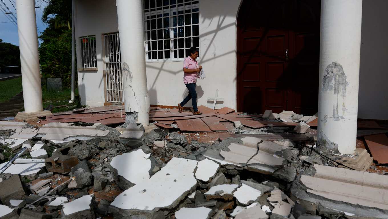 AME5709. LA COLORADA (PANAMÁ), 13/10/2026.- Fulvia Pérez camina este martes entre los escombros ocasionados por el terremoto de magnitud 7,7 del pasado viernes en la Capilla de San Sebastián en La Colorada (Panamá). El potente terremoto que azotó a Panamá, causó daños en las residencias de 2.164 familias, entre ellas 506 que registraron la pérdida total de sus hogares, según el último reporte oficial. EFE/ Bienvenido Velasco