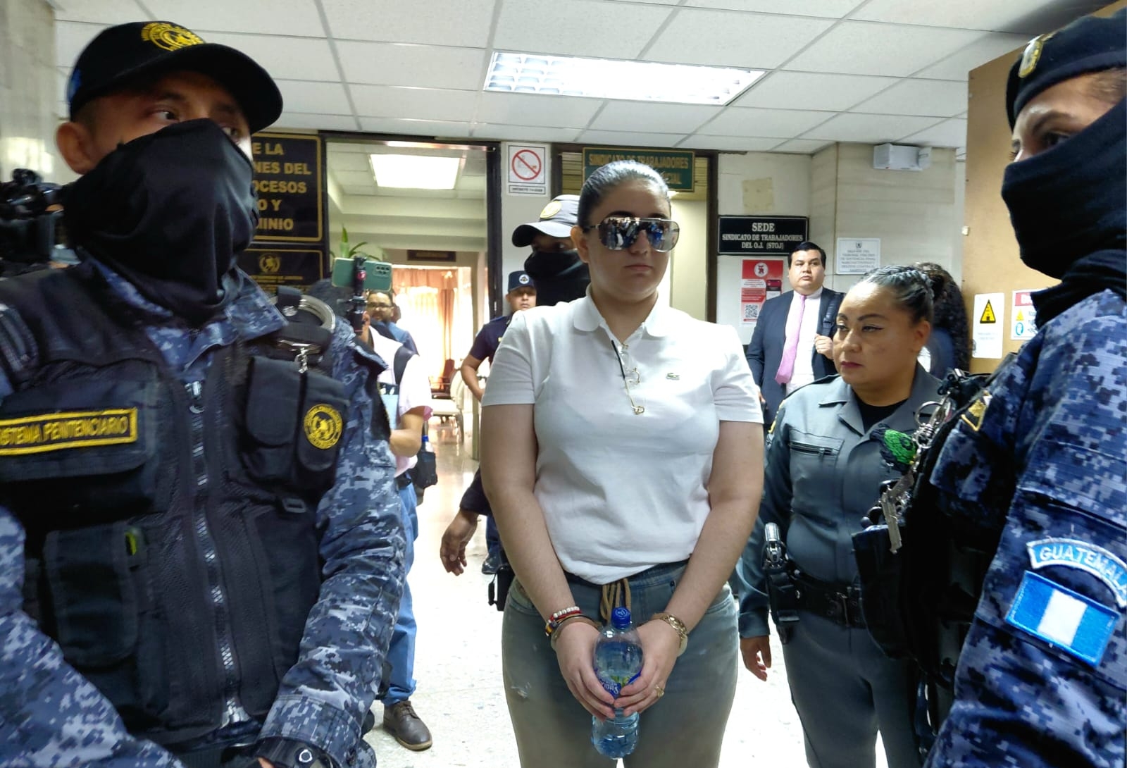 María Fernanda Bonilla, procesada por la muerte de Melisa Palacios, permanece acompañada por agentes de seguridad durante una diligencia judicial. (Foto Prensa Libre: Elmer Vargas)