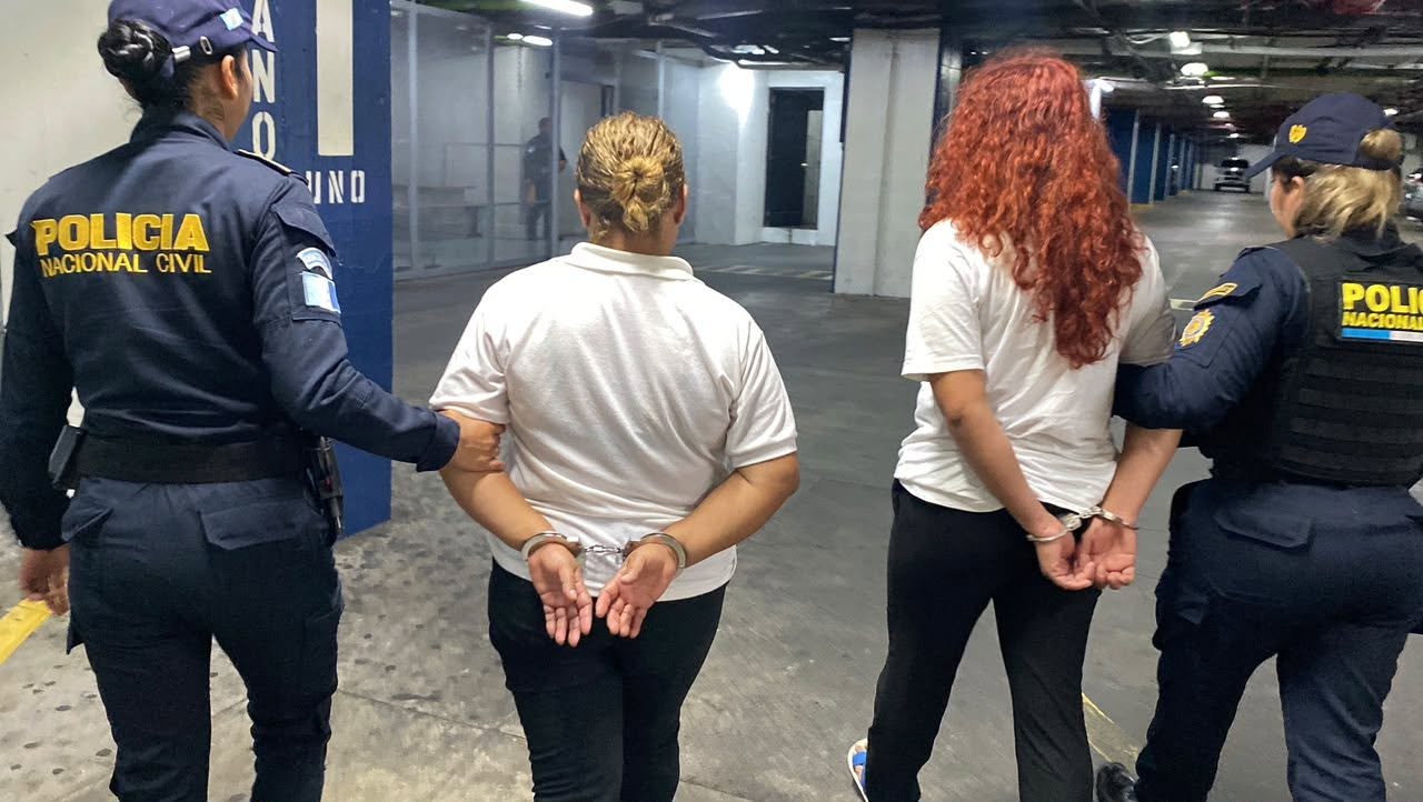 Agentes de la PNC trasladas a las dos mujeres que intentaron ingresar marihuana al centro correccional Gaviotas de la zona 13. (Foto Prensa Libre: PNC)