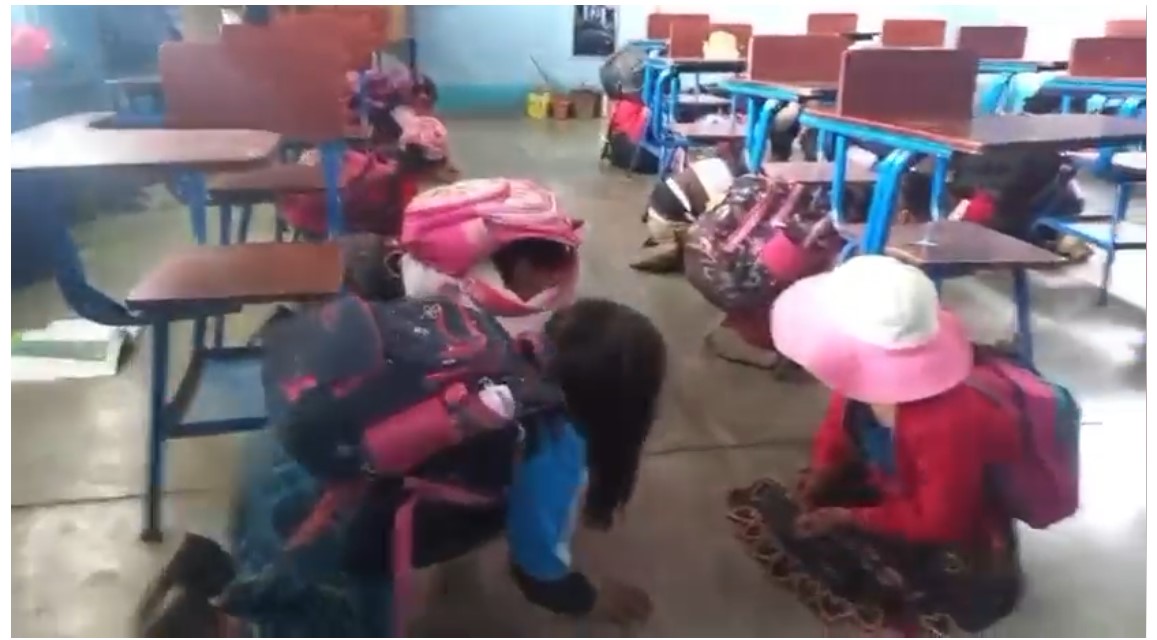 Un grupo de niñas se refugia bajo sus escritorios al escuchar disparos cerca de su escuela, en la zona de conflicto entre Tajumulco e Ixchiguán, San Marcos. (Foto Prensa Libre: Captura de Pantalla)
