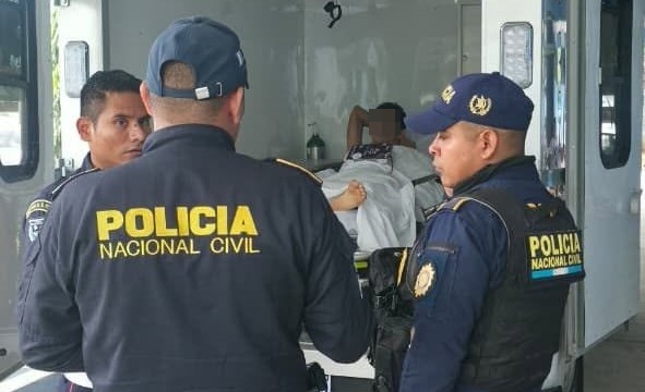 Bajo custodia policial, un salvadoreño requerido por la justicia de su país es trasladado en ambulancia hacia la frontera con El Salvador, después de recibir el alta médica en un hospital de Petén. (Foto Prensa Libre: PNC)