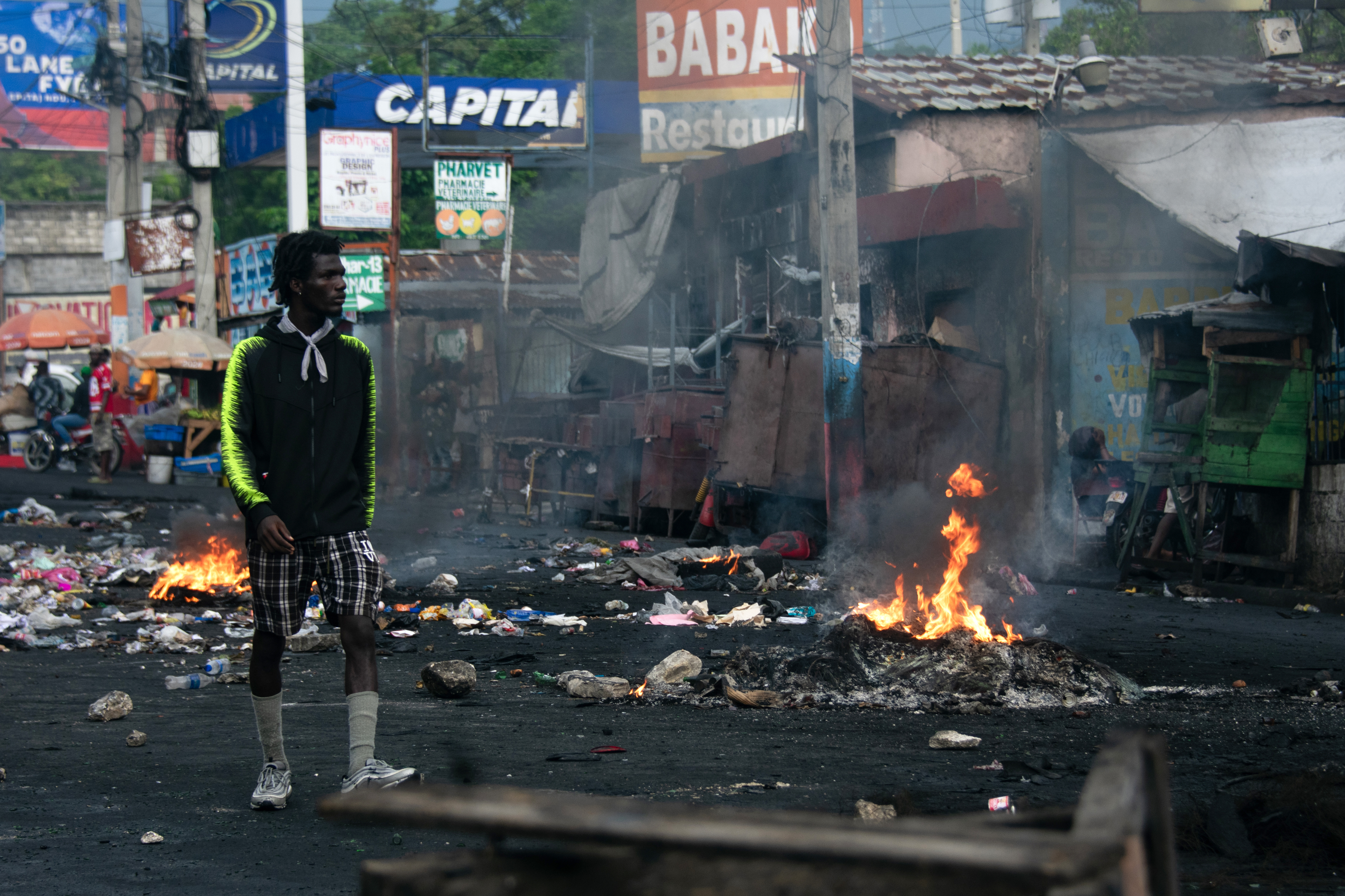 Un hombre camina junto a una barricada durante una protesta de familias desplazadas por la violencia de las pandillas en Puerto Príncipe, Haití. (Foto Prensa Libre: EFE)