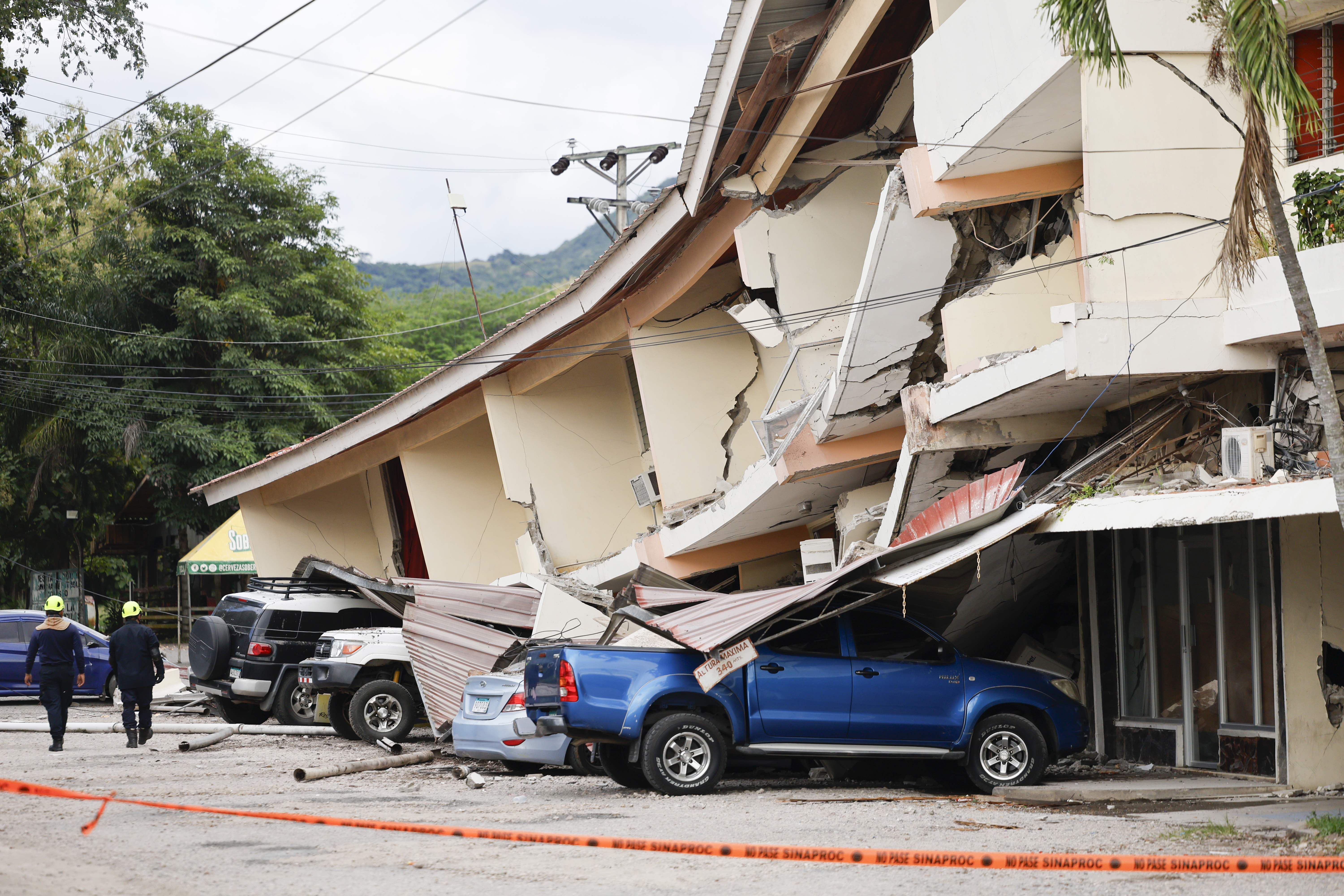 FOTODELDÍA AME4622. PENONOMÉ (PANAMÁ), 09/10/2026.- Socorristas caminan frente a una edificación afectada por el terremoto de magnitud 7,7 que sacudió el sureste de Panamá, con una profundidad de 10 kilómetros y generó daños en varios edificios y carreteras cercanas a la localidad de Tonosí, epicentro del temblor, este viernes en Penonomé (Panamá). EFE/ Bienvenido Velasco