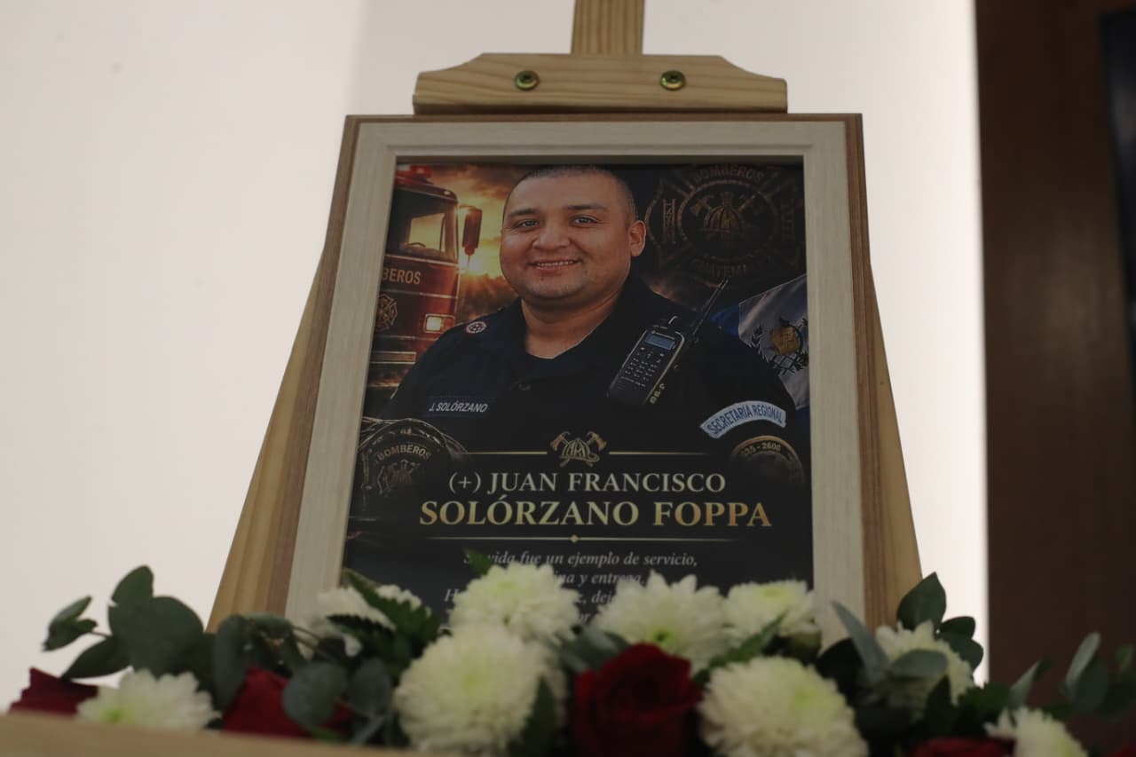 Un retrato de Juan Francisco Solórzano Foppa, rodeado de flores blancas y rojas, forma parte del homenaje en su memoria tras su asesinato. (Foto Prensa Libre: Juan Diego González)