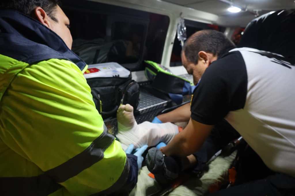 Bomberos Voluntarios atienden a una persona que sufrió una lesión en una pierna tras la caída de un árbol en la zona 3.