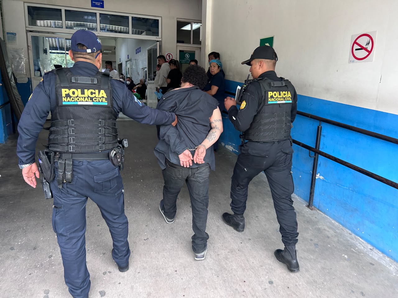 Agentes de la Policía Nacional Civil trasladan a Julio “M”, alias “Pirata”, presunto integrante de la Mara 18, luego de que vecinos lo vapulearan en la colonia La Florida, zona 19. (Foto Prensa Libre: PNC)
