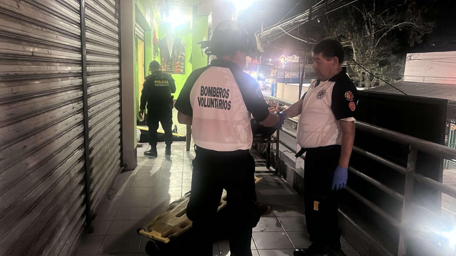 Socorristas de los Bomberos Voluntarios trabajan en el lugar del ataque armado contra comensales de una venta de comida en la zona 1 de Villa Canales, donde dos personas murieron y tres resultaron heridas. (Foto Prensa Libre: CVB)