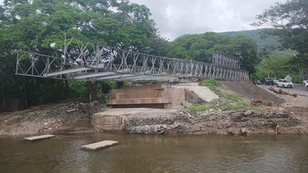 Vista lateral del avance de instalación del puente modular Güijo en Zacapa, con su estructura metálica sobre la corriente crecida del río, a diferencia del momento del accidente sin lluvias.