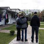 Vitaly, his wife, Iryna, and their 13-year-old son stand outside a complex in Kyiv for displaced Ukrainians. They survived the summer in Oleshky by sharing one cup of rice or buckwheat each day. (Heidi Levine/For The Washington Post)